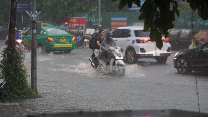 Mưa lớn bất ngờ ở Hà Nội khiến nhiều người trở tay không kịp, xe cộ vật lộn trong nước - Ảnh 2.