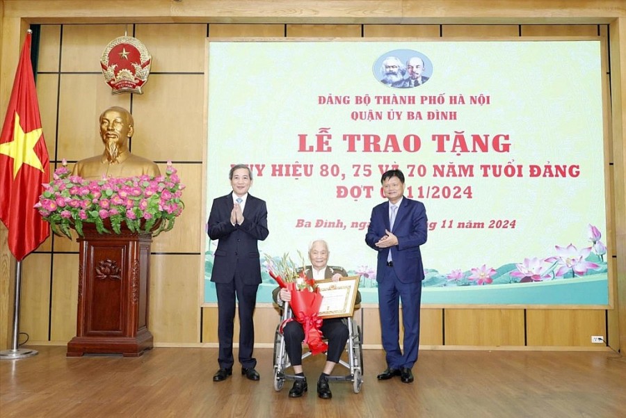 Trưởng ban Tổ chức Thành ủy Vũ Đức Bảo và Bí thư Quận ủy Ba Đình Hoàng Minh Dũng Tiến trao Huy hiệu 80 năm tuổi Đảng tặng đảng viên lão thành. Ảnh: Mai Hữu