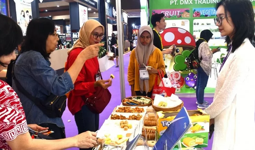 Khách tham quan thích thú thử sản phẩm của Việt Nam ở Triển lãm SIAL Interfood 2024 tổ chức tại Indonesia