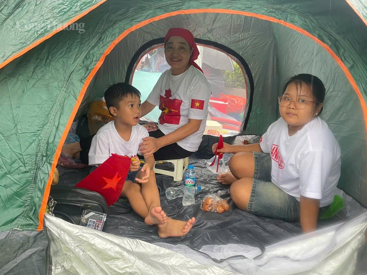 Cô Phạm Thị Bích Nhiễn (60 tuổi, áo trắng) ở Phú Thọ cho hay: ”Gia đình cô từ Phú Thọ tới Hà Nội lúc từ 3h sáng. Vì trời mưa to nên gia đình mang theo lều dựng tạm cho các cháu không bị ướt, hơn nữa thời gian chờ cũng khá lâu nên cô mạnh theo cả đồ ăn, nước uống, quần áo để thay nếu bị ướt”.