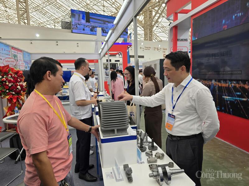 Ông Nguyễn Hoàng Giang (bên phải) đang xem các sản phẩm của VEAM được trưng bày tại hội chợ