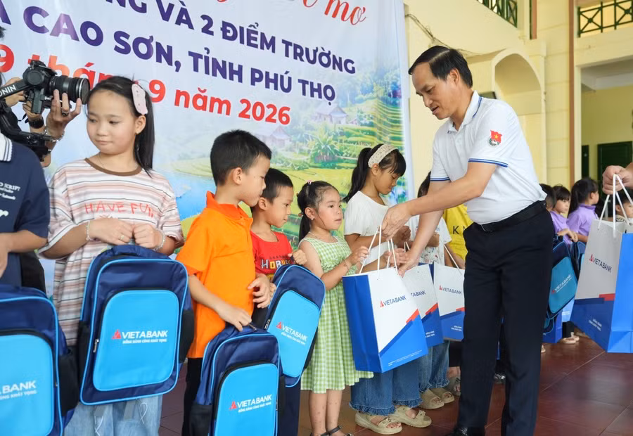 Ông Đoàn Hùng Sơn, Phó Giám đốc Ngân hành Nhà nước Khu vực 1 trao quà cho các em học sinh.